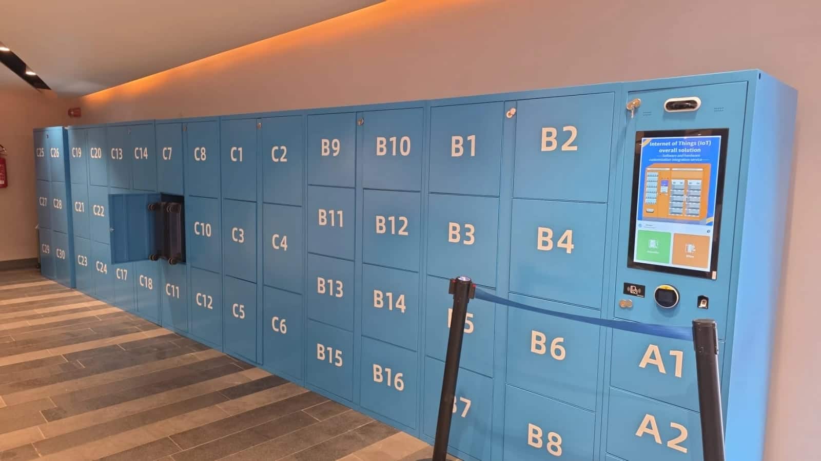 La parete di armadietti blu per i bagagli con il totem touch screen dentro il terminal del Molo Beverello, Napoli
